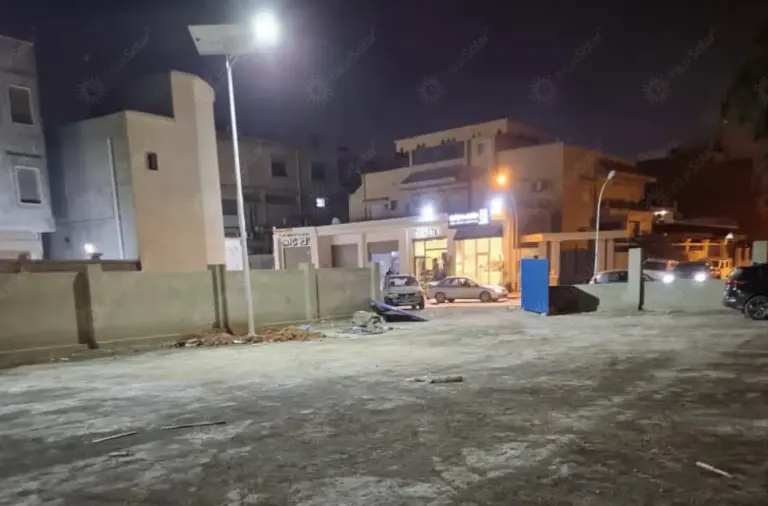 Two solar street light poles illuminating an open site during night testing