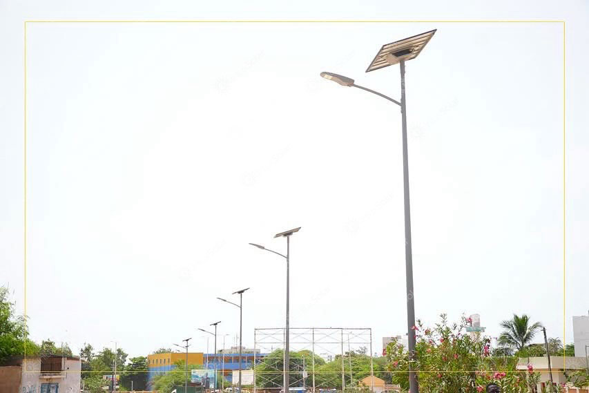Single split type solar street light beside a fenced roadway in Dakar