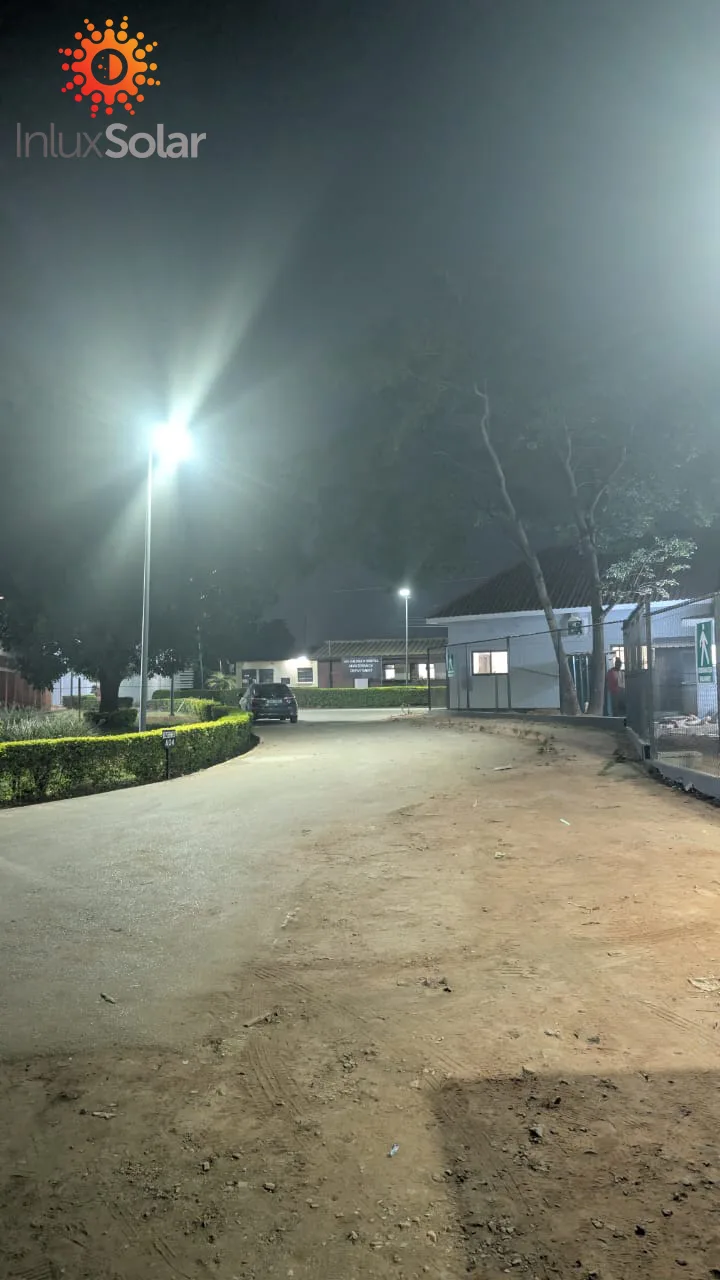 Two-sided solar street lighting layout on a Zambian town road, with a 20 km/h speed sign and lit carriageway markings