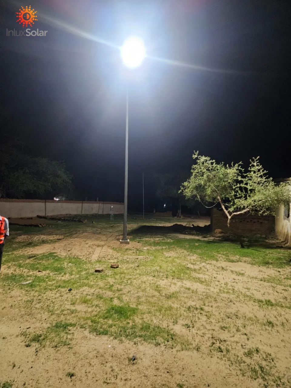 One installed AIO6 solar street light illuminating an open rural area at night